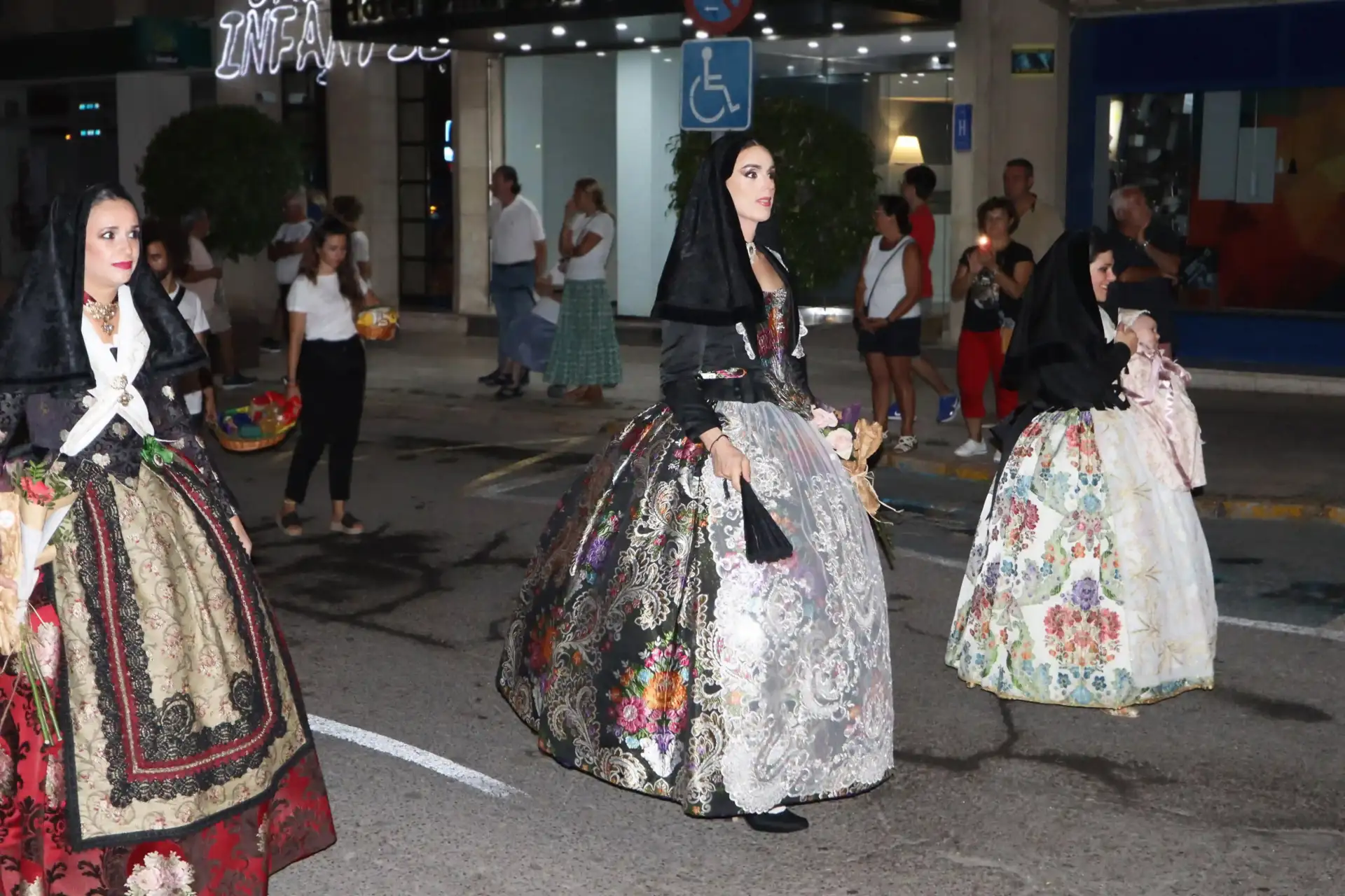Peter junto a dos mujeres haciendo el trayecto de la ofrenda vestides con el traje tradicional de mujer.