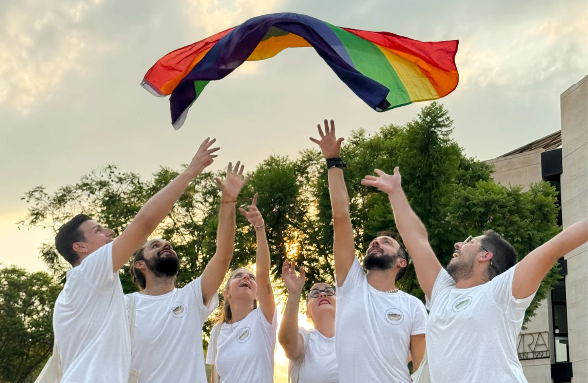 Seis miembres de Colors de l'Horta tiran al aire una bandera LGTBI.