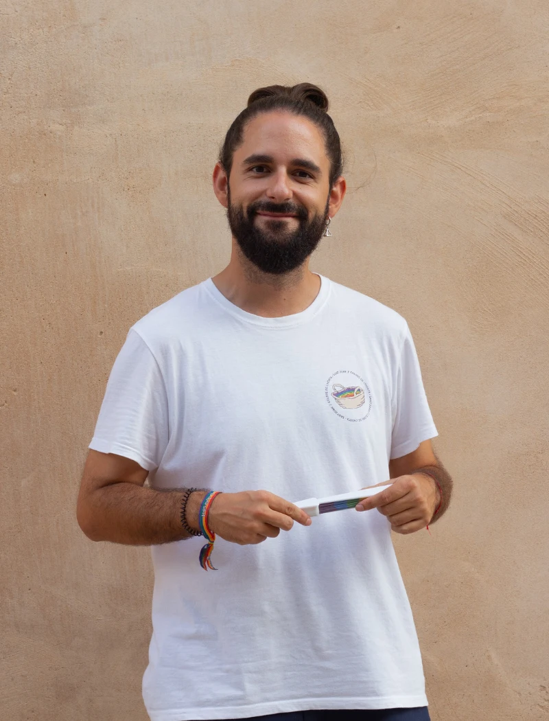 Fotografía de Dani Sarabia. Hombre blanco con pelo largo recogido en un moño y barba. Pelo castaño y camiseta de colors de l'Horta blanca.